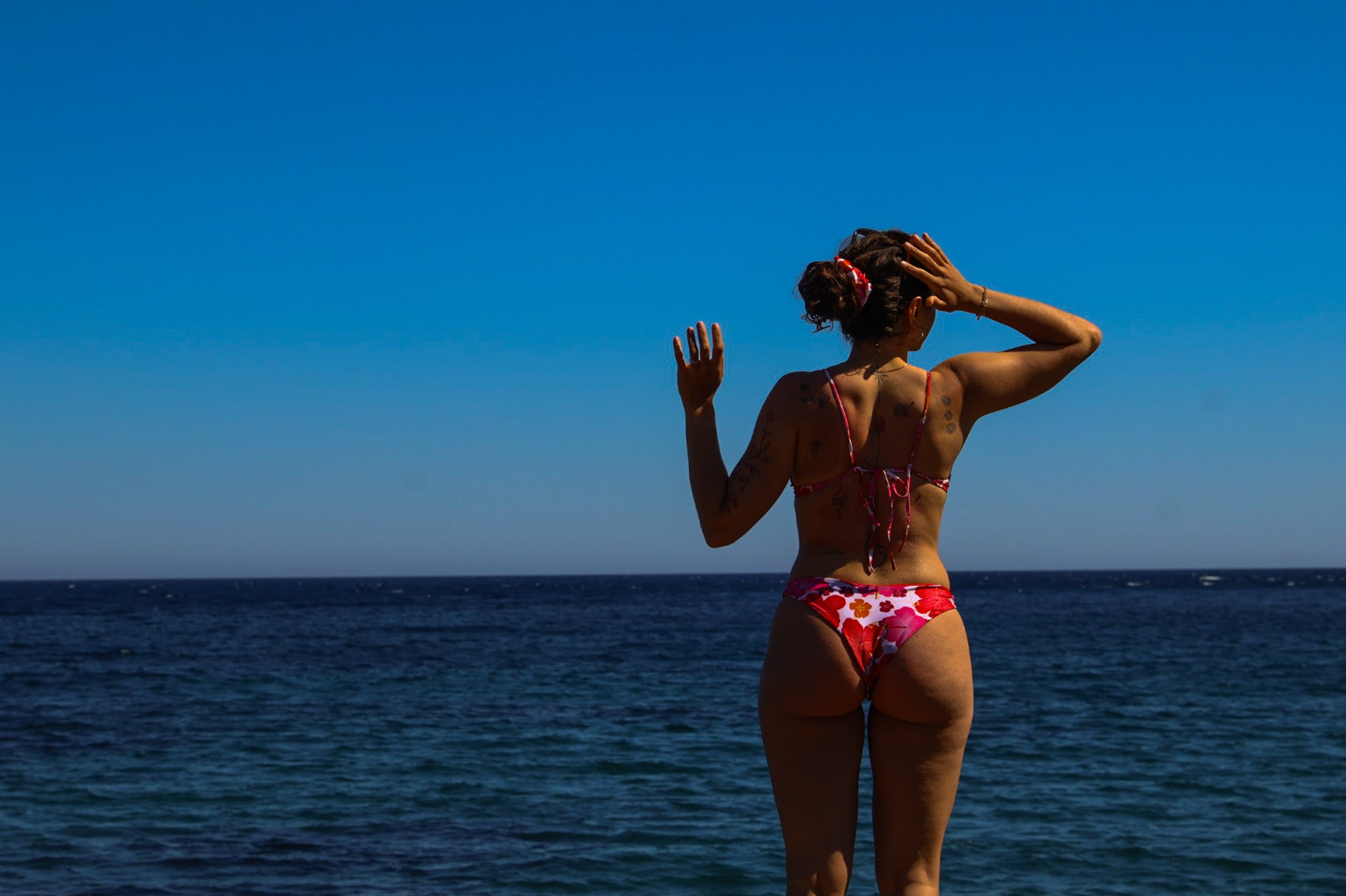 Femme portant le maillot de bain menstruel réversible Manaiki modèle Tiaré avec pad amovible