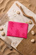 Pochette de plage ARU à imprimé feuille tropicale. Réalisée dans la matière de nos maillots de bain, idéale pour ranger pads, maillot et essentiels d'été.